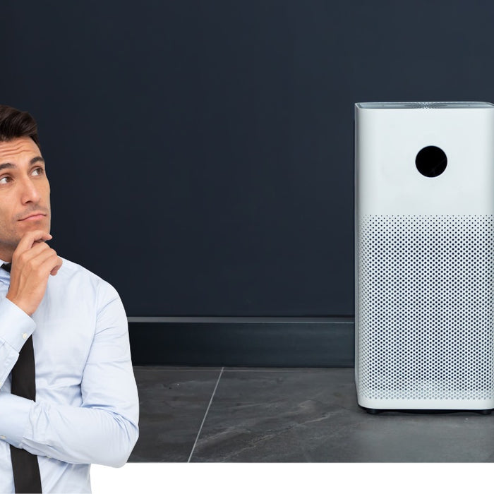 Man in thinking pose looking at an air purifier