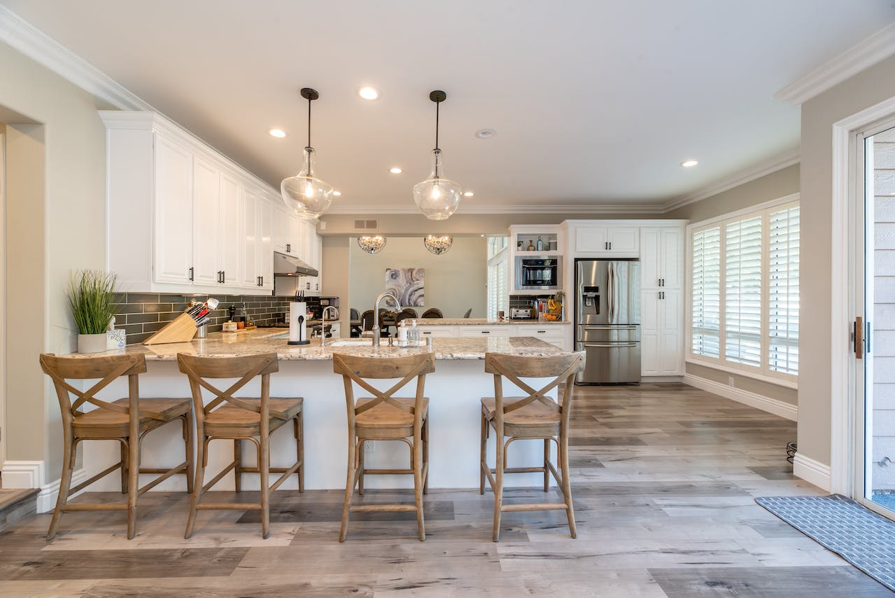 Elegant and spacious kitchen interior with a large marble island, rustic bar stools, and modern pendant lights, an ideal setting for a large room air purifier to ensure clean indoor air quality