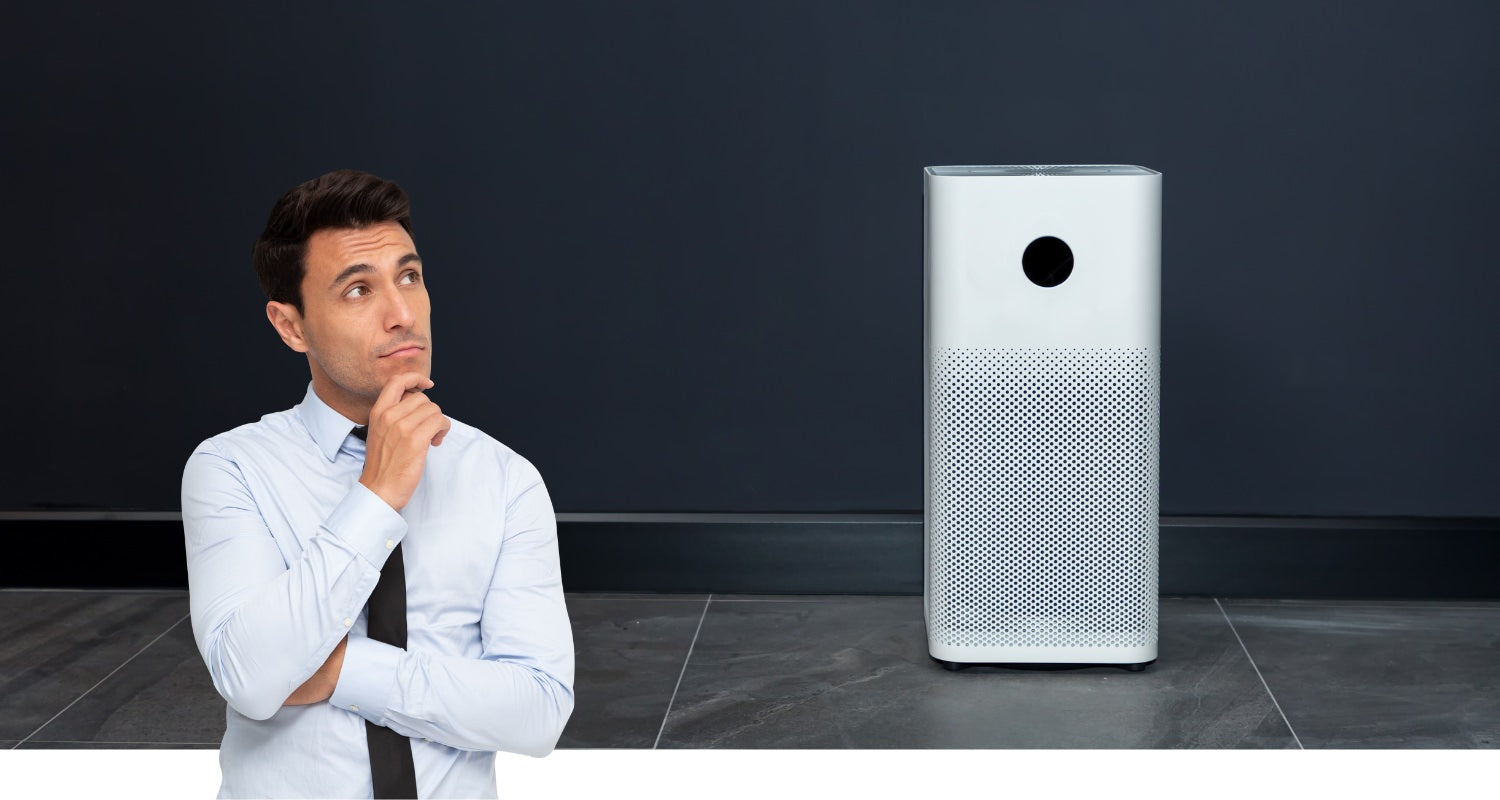 Man in thinking pose looking at an air purifier