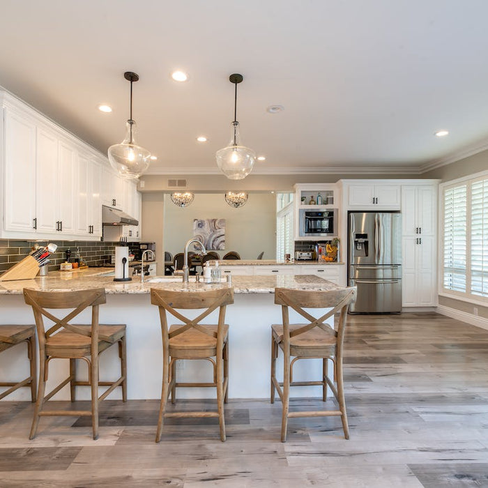 Elegant and spacious kitchen interior with a large marble island, rustic bar stools, and modern pendant lights, an ideal setting for a large room air purifier to ensure clean indoor air quality