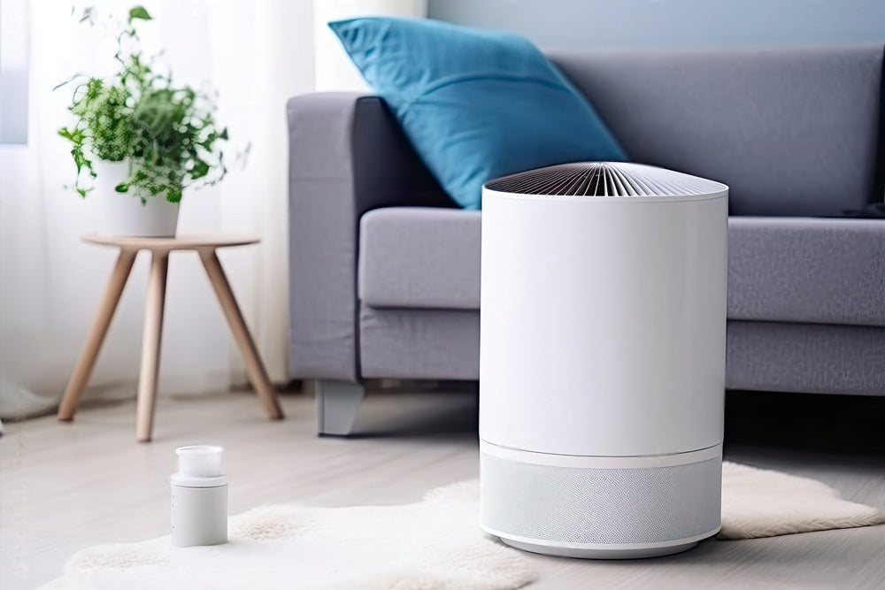 Cylindrical white air purifier in the living room in front of the couch picturing the topic: "Signs you need an air purifier"