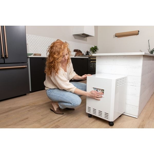 EnviroKlenz Air System Plus in kitchen with a woman turning on the machine