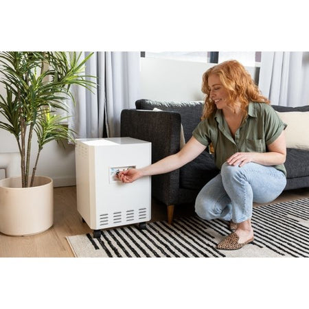 EnviroKlenz Air System Plus in living room with woman turning on the machine