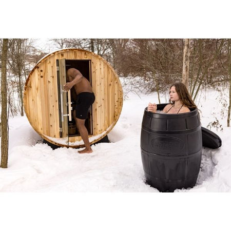 Ice Barrel with woman inside and man going into a sauna in the outdoors